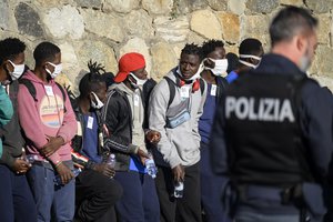 Migrants disembark from the German humanitarian ship Rise Above docked in the southern Italian port town of Reggio Calabria, Tuesday, Nov. 8, 2022.German humanitarian group Mission Lifeline said its ship docked in southern Italy early Tuesday and disembarked the 89 people it had rescued in the central Mediterranean.