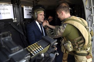 File - A French soldier adjusts the helmet of French President Emmanuel Macron prior to the take off with a military helicopter during his visit to the troops of Operation Barkhane, France's largest overseas military operation, in Gao, northern Mali, Friday, May 19, 2017.