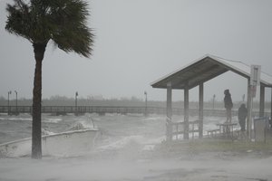 People brave rain and heavy winds to visit the waterfront along the Jensen Beach Causeway, as conditions deteriorate with the approach of Hurricane Nicole, Wednesday, Nov. 9, 2022, in Jensen Beach