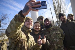 In this photo provided by the Ukrainian Presidential Press Office and posted on Facebook, Ukrainian soldiers take a selfie with President Volodymyr Zelensky, centre, during his visit to Kherson, Ukraine, Monday, Nov. 14, 2022.