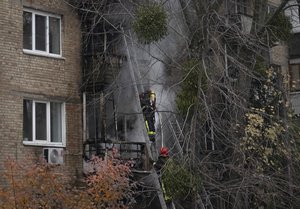 Ukrainian State Emergency Service firefighters work to extinguish a fire at the scene of a Russian shelling in Kyiv, Ukraine, Tuesday, Nov. 15, 2022