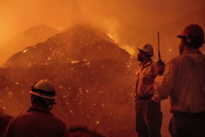 Firefighters monitor the Thomas fire as it burns through Los Padres National Forest near Ojai, Calif., on Friday, Dec. 8, 2017.