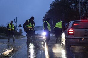 A police officers check documents at a checkpoint near the scene of a blast in Przewodow, Poland, Wednesday, Nov. 16, 2022