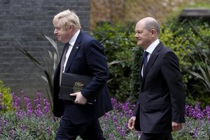 Boris Johnson and Olaf Scholz walk along Downing Street after attending a press conference in London