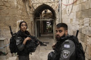 Israeli border police officers stand guard next to the scene of a stabbing attack in Jerusalem's Old City, Thursday, Nov. 3, 2022. A Palestinian stabbed a police officer lightly wounding him, and officers opened fire on the attacker, killing him, Israeli police said.