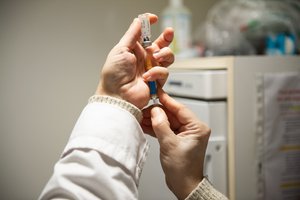 A nurse filling a syringue with the influenza vaccine at Air France's international vaccination centre