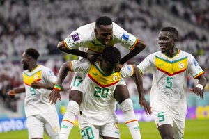 Temmates celebrate with Senegal's Bamba Dieng after he score their third goal against Qatar during a World Cup group A soccer match at the Al Thumama Stadium in Doha, Qatar, Friday, Nov. 25, 2022