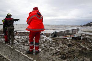 Rescuers look at a bus covered by mud after heavy rainfall triggered landslides that collapsed buildings and left as many as 12 people missing, in Casamicciola, on the southern Italian island of Ischia, Saturday, Nov. 26, 2022