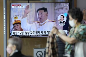 A TV screen showing a news program reporting about Kim Jong Un at the Railway Station in Seoul