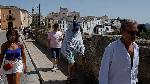 A tourist covers his body with a blanket to avoid the sun to cool off during the first heatwave of the year in Ronda, Spain, June 12, 2022. REUTERS/Jon Nazca