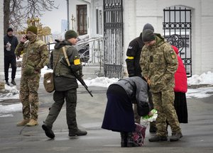 Ukraine's secret service examine belonging of a parishioner at the entrance to the Pechersk Lavra monastic complex in Kyiv, Ukraine, Tuesday, Nov. 22, 2022. Ukraine's counter-intelligence service, police officers and the country's National Guard searched one of the most famous Orthodox Christian sites in the capital, Kyiv, after a priest spoke favorably about Russia