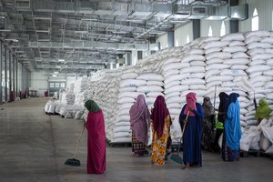 File: Workers clean the floor as sacks of food earmarked for the Tigray and Afar regions sits in piles in a warehouse of the World Food Programme (WFP) in Semera, the regional capital for the Afar region, in Ethiopia on Feb. 21, 2022. Ethiopia's lead negotiator in ongoing peace talks asserted Friday, Nov. 11, 2022 that 70% of the Tigray region is now under military control and aid deliveries have resumed to the area, but there is no immediate confirmation from aid workers or Tigray spokesmen.