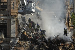 Rescuers clearing rubble from a residential building destroyed by a kamikaze drone attack in downtown Kyiv, Ukraine