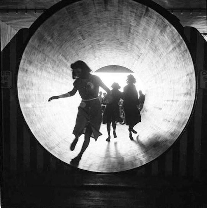 The barrel: girls in silhouette, running through a spinning barrel ride at Steeplechase Park, Coney Island, Brooklyn, New York, 1939 - by Andrew Herman, American