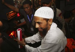 Umar Patek, an Indonesian militant charged in the 2002 Bali terrorist attacks, walks outside the courtroom after his trial in Jakarta, Indonesia, Monday, Feb. 13, 2012.