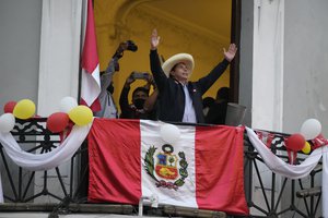 Presidential candidate Pedro Castillo waves to supporters celebrating partial election results that show him leading over Keiko Fujimori