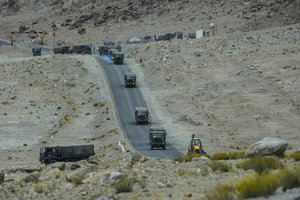 Indian army vehicles move in a convoy in the cold desert region of Ladakh, India, Tuesday, Sept. 20, 2022