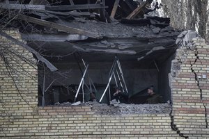 People check a tax office building, that was heavily damaged in Russian shelling, in Kyiv, Ukraine, Wednesday, Dec. 14, 2022.