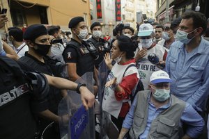 File - Turkish police officers, wearing masks to protect from the spread of coronavirus, block supporters of pro-Kurdish People's Democratic Party (HDP), as they try to gather for a rally in Istanbul, Wednesday, June 17, 2020.