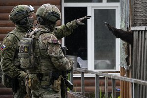 Russian soldiers play with a bear at the zoo in Mariupol, in territory under the government of the Donetsk People's Republic, eastern Ukraine, Wednesday, May 18, 2022