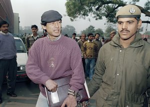 File: Serial killer Charles Sobhraj, left, at one time wanted in eight different countries for crimes ranging from car theft to murder, arrives handcuffed by police at a courthouse in New Delhi, India, Jan. 20, 1993. Sobhraj has been released from prison in Nepal after serving most of his sentence, Kathmandu, Nepal, Friday, Dec. 23, 2022.