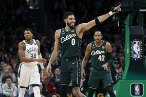 Boston Celtics forward Jayson Tatum (0) celebrates after making a basket as teammate Al Horford (42) and Milwaukee Bucks forward Giannis Antetokounmpo (34) look on during the second half of an NBA basketball game, Sunday, Dec. 25, 2022, in Boston.