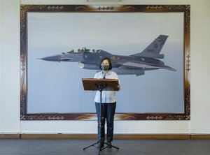 In this photo released by the Taiwan Presidential Office, Taiwan's President Tsai Ing-wen speaks in front of a picture of a Taiwanese F16 fighter jet at an airbase in Hualien in eastern Taiwan on Tuesday, Sept. 6, 2022