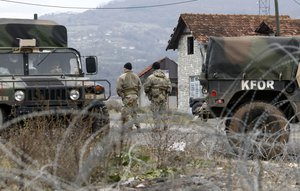 US soldiers serving in NATO-led peacekeeping force KFOR, guard a checkpoint on the road near the northern Kosovo border crossing of Jarinje, along the Kosovo-Serbia border, Kosovo, Sunday, Dec. 18, 2022