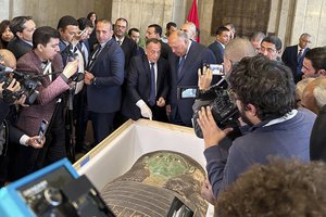 Foreign Minister Sameh Shoukry, center right, and Mostafa Waziri, top official at the Supreme Council of Antiquities, talk in front of an ancient wooden sarcophagus