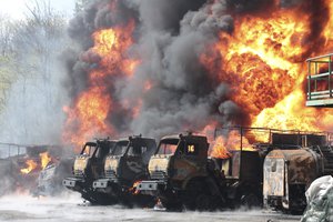 File - Vehicles on fire at the oil depot after missiles struck the facility in an area controlled by Russian-backed separatist forces in Makiivka, 15 km (94 miles) east of Donetsk, eastern Ukraine, Wednesday, May 4, 2022.