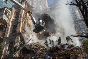 File - Firefighters work after a drone attack on buildings in Kyiv, Ukraine, Monday, Oct. 17, 2022.