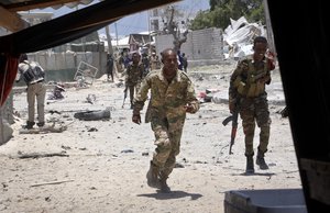 Somali government soldiers run to take positions during ongoing fighting with gunmen after a suicide car bomb attack on a government building in the capital Mogadishu, Somalia Saturday, March 23, 2019.