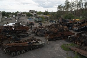 A Ukrainian serviceman and journalists walk between destroyed Russian equipment placed in an area at the recaptured town of Lyman, Ukraine, Wednesday, Oct. 5, 2022