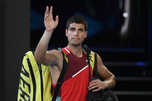 FILE- Carlos Alcaraz of Spain waves as he leaves Rod Laver Arena following his third round loss to Matteo Berrettini of Italy at the Australian Open tennis championships in Melbourne, Australia, on Jan. 21, 2022.