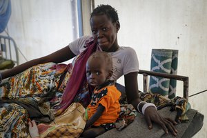 File - A mother sits with her malnourished baby at a hospital run by Medicines Sans Frontieres (Doctors Without Borders) in Old Fangak in Jonglei state, South Sudan Tuesday, Dec. 28, 2021. Aid groups say more people than ever in the country will face hunger this year, because of the worst floods in 60 years as well as conflict and the sluggish implementation of the peace agreement that has denied much of the country basic services.