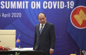 Vietnamese Prime Minister Nguyen Xuan Phuc walks to his desk ahead of the Special ASEAN summit on COVID-19 in Hanoi