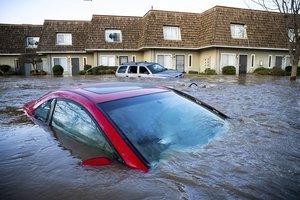 Floodwaters course through a neighborhood in Merced, California, on Tuesday, Jan. 10, 2023. Following days of rain, Bear Creek overflowed its banks leaving dozens of homes and vehicles surrounded by floodwaters.