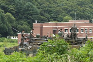 South Korean army soldiers work on armored vehicles to hold an exercise at a training field in Paju, South Korea, near the border with North Korea, Monday, Aug. 2, 2021