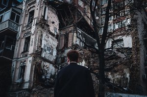 Man is standing near destroyed concrete building, Kyiv, Ukraine