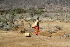 File - A Samburu woman fetches water during a drought in Loolkuniyani Primary School, Samburu county, Kenya on Oct. 16, 2022.  Earth’s fever persisted last year, not quite spiking to a record high but still in the top five or six warmest on record, government agencies reported Thursday, Jan. 12, 2023.