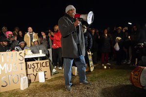 Rev. Andre E Johnson, of the Gifts of Life Ministries, preaches at a candlelight vigil for Tyre Nichols, who died after being beaten by Memphis police officers, in Memphis, Tenn., Thursday, Jan. 26, 2023. Behind at left are Tyre's mother RowVaughn Wells and his stepfather Rodney Wells.