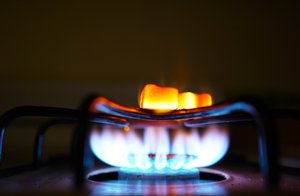 A gas-lit flame burns on a natural gas stove