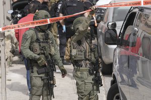 Israeli policemen secure a shooting attack site in east Jerusalem, Saturday, Jan. 28, 2023.