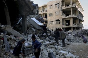 People remove furniture and household appliances out of a collapsed building after a devastating earthquake rocked Syria and Turkey in the town of Jinderis, Aleppo province, Syria, Tuesday, Feb. 7, 2023. The quake has brought down thousands of buildings and killed thousands of people. In Syria, it also came on the heels of over a decade of conflict and a crippling economic crisis.