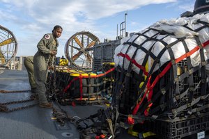 In this image released by the U.S. Navy, sailors assigned to Assault Craft Unit 4 prepare material recovered off the coast of Myrtle Beach, S.C., in the Atlantic Ocean from the shooting down of a Chinese high-altitude balloon, for transport to the FBI, at Joint Expeditionary Base Little Creek in Virginia Beach, Va., on Feb. 10, 2023.