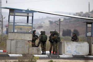 Israeli soldiers secure the area after a Palestinian gunman opened fire at a military post and troops returned fire, at the Huwara checkpoint south of the West Bank city of Nablus, Wednesday, Nov. 4, 2020.