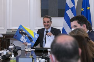 Image showing Greek Prime Minster Kyriakos Mitsotakis, holds a leaflet handed over to him on behalf of Valdis Dombrovskis, during a tele-conference, Greece, Leros, April 8, 2022.