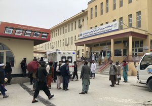 People stand outside a hospital after a bomb blast in Mazar-e Sharif, the capital city of Balkh province, in northern Afghanistan, Thursday, March 9, 2023