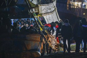 Some 500 migrants start disembarking from a fishing boat in the southern Italian port of Crotone, early Saturday, March 11, 2023