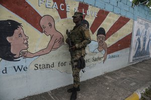 A soldier stands guard at a checkpoint in the August Town community of Kingston, Jamaica, Wednesday, Dec. 7, 2022